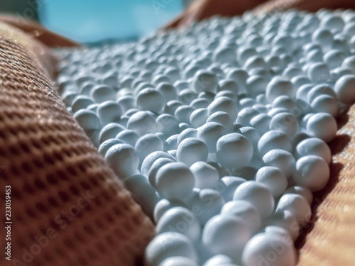 zoomed white expanded polystyrene pellets for production plastic bags.Polystyrene pellets on bright background.