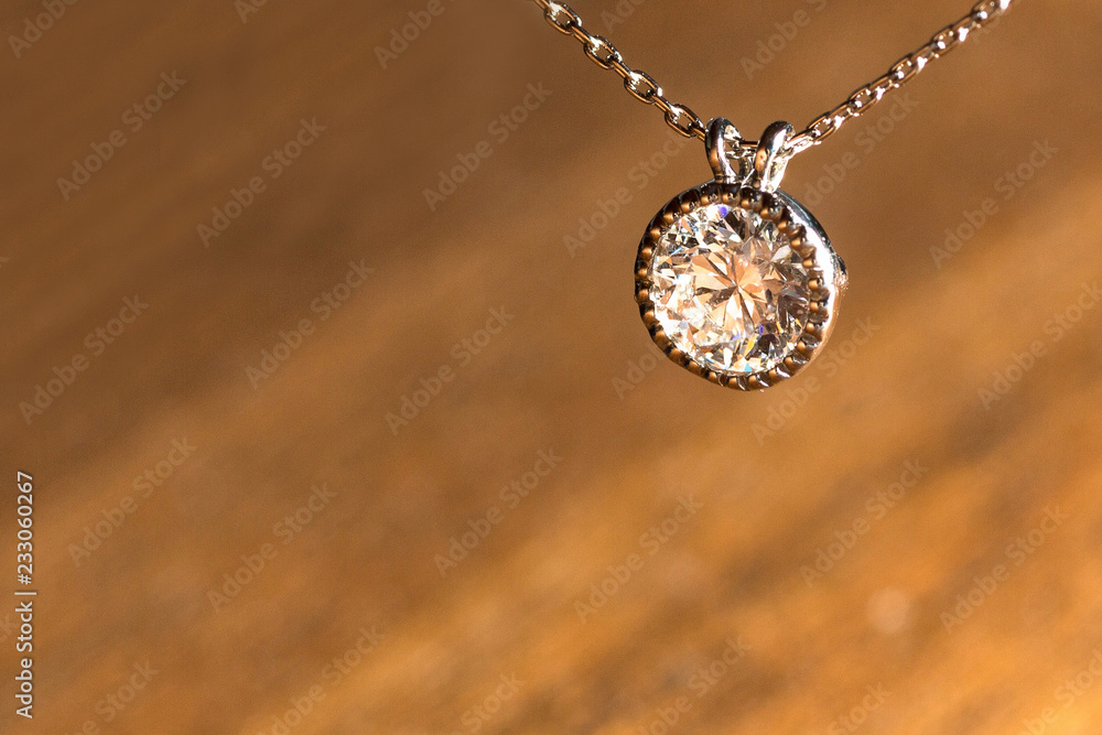 Fototapeta premium Bezel Diamond Pendant Necklace Against Diagonal Wooden Textured Background