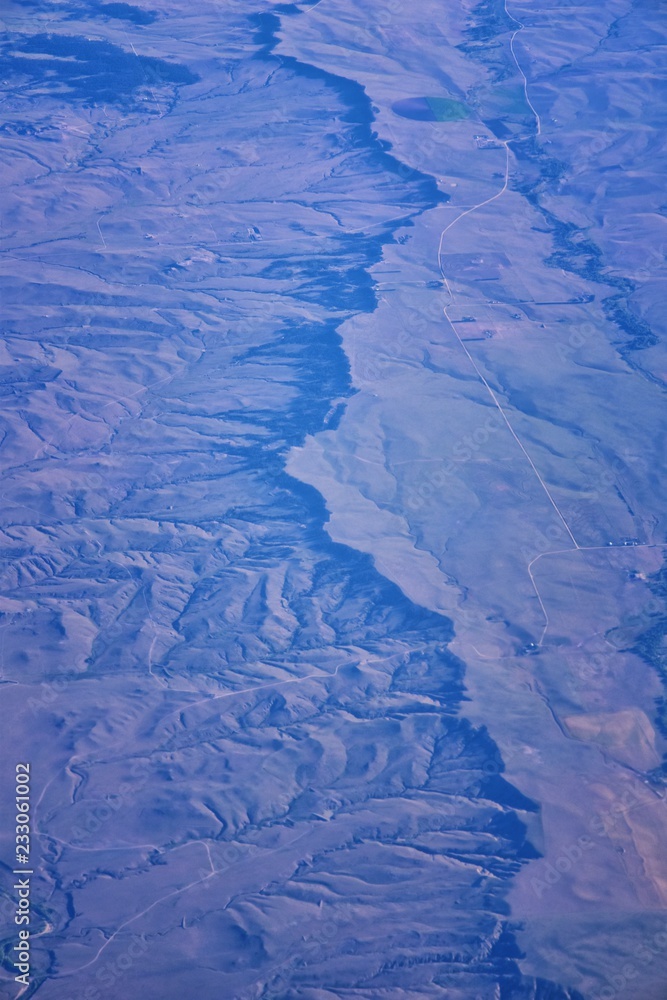 Fototapeta premium Aerial view of topographical landscapes over midwest states on flight over Colorado, Kansas, Missouri, Illinois, Indiana, Ohio and West Virginia during autumn. Grand sweeping views of crops, rivers, p