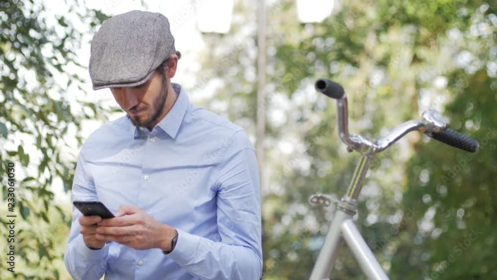 Young stylish male with retro bicycle riding on the streets in sunny day, portrait modern businessman with cellphone Young stylish male with retro bicycle riding on the streets in sunny day, portrait modern businessman with cellphone