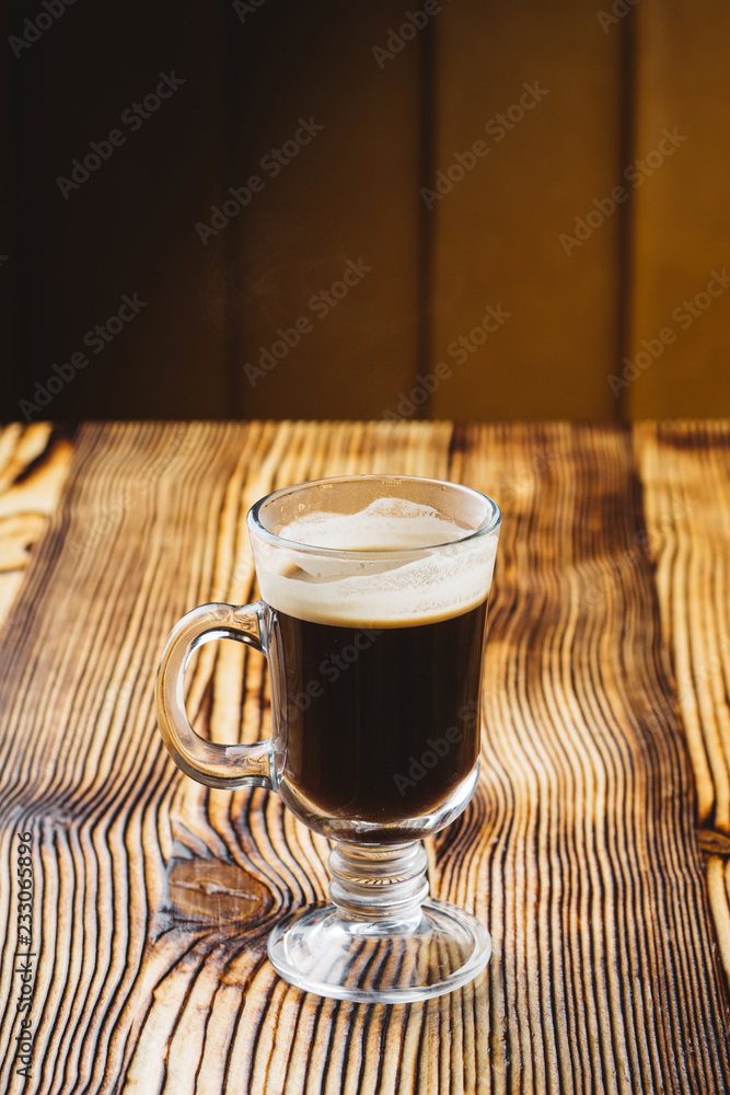 glass coffee cup on rustic textured wooden table with dark light glass coffee cup on rustic textured wooden table with dark light