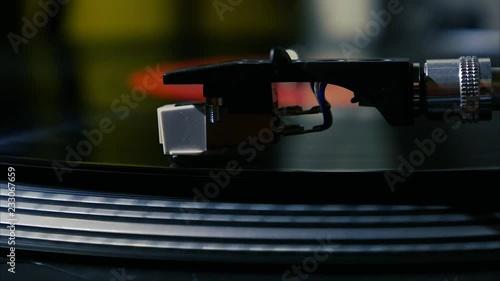 A needle is put down on the spinning black vinyl on the turntable photo