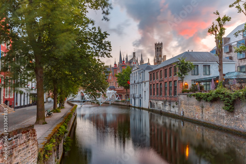 Scenic cityscape with a medieval tower Belfort and the Green canal, Groenerei, at sunset in Bruges, Belgium