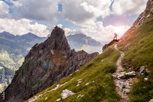 Single Hiker on a Narrow Mountain Path in the Sunlight
