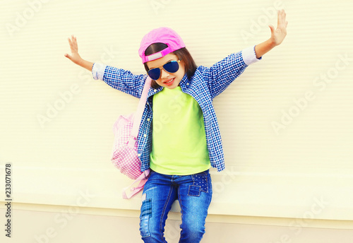 Fashion little girl child in baseball cap having fun in city on white background