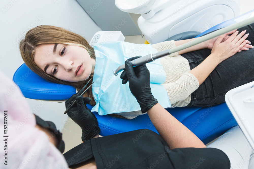 Dental clinic. Reception, examination of the patient. Teeth care. Dentist curing a girl patient Dental clinic. Reception, examination of the patient. Teeth care. Dentist curing a girl patient