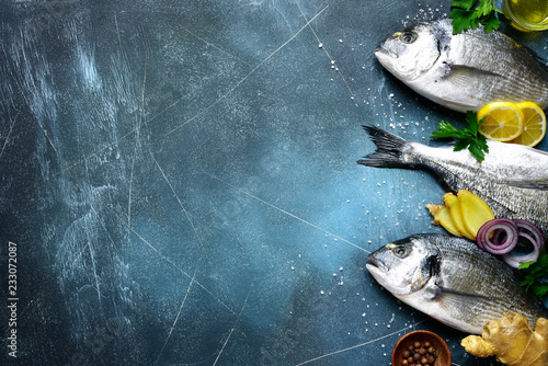 Food background with fresh raw dorado fish with ingredients for making.Top view with copy space. photo