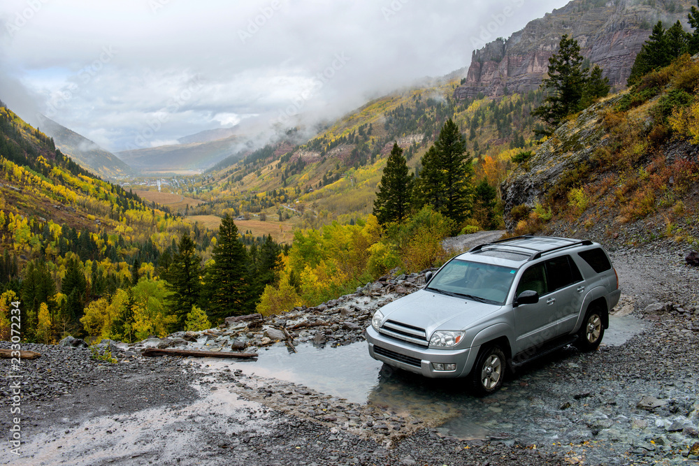 Rainy Day on Mountain Trail - On a rainy and foggy autumn day, a SUV's driving through a mountain creek on rugged Black Bear Pass trail, near Telluride, CO, USA.