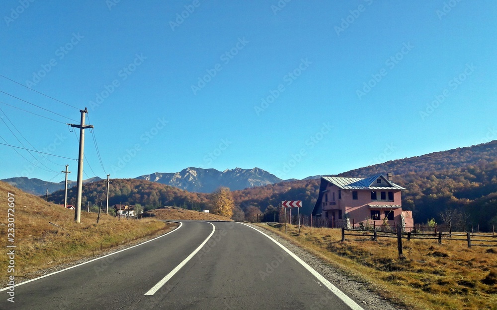 Road to the mountains. Fall season. House in construction
