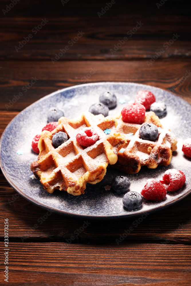 waffles with fresh blueberries, sugar and raspberries. waffles with fresh blueberries, sugar and raspberries.