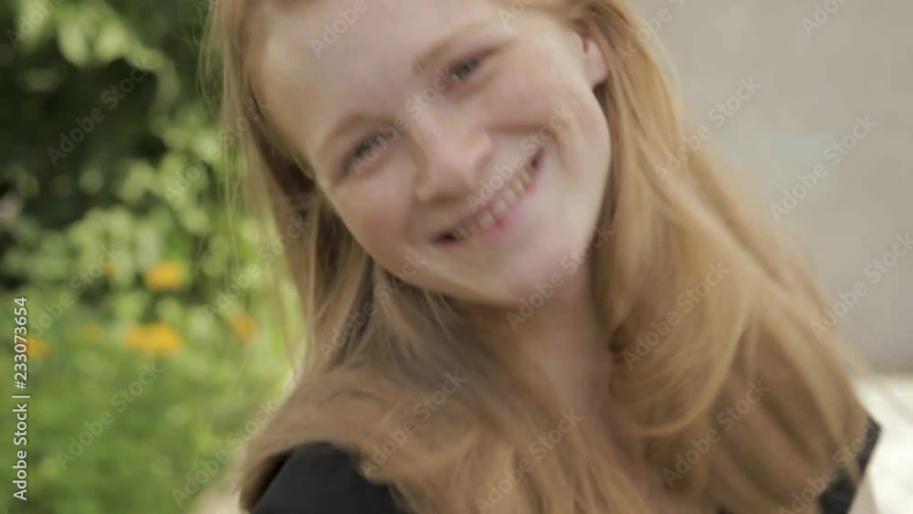Close up young adorable emotional redhead woman with freckles in black t-shirt having fun flower bed background. Close up young adorable emotional redhead woman with freckles in black t-shirt having fun flower bed background.