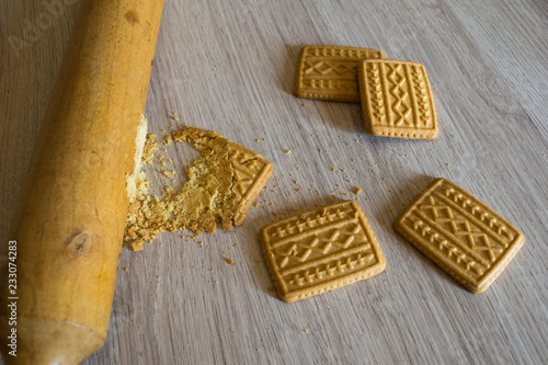 Photos crushing cookies with wooden rolling pin for pie