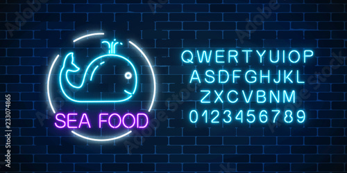 Neon glowing sign of sea food with blue whale in circle frame with alphabet. Fastfood light billboard symbol.
