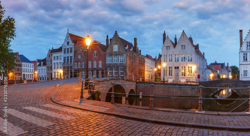 Scenic city view of Bruges canal with beautiful medieval colored houses and bridge, Belgium