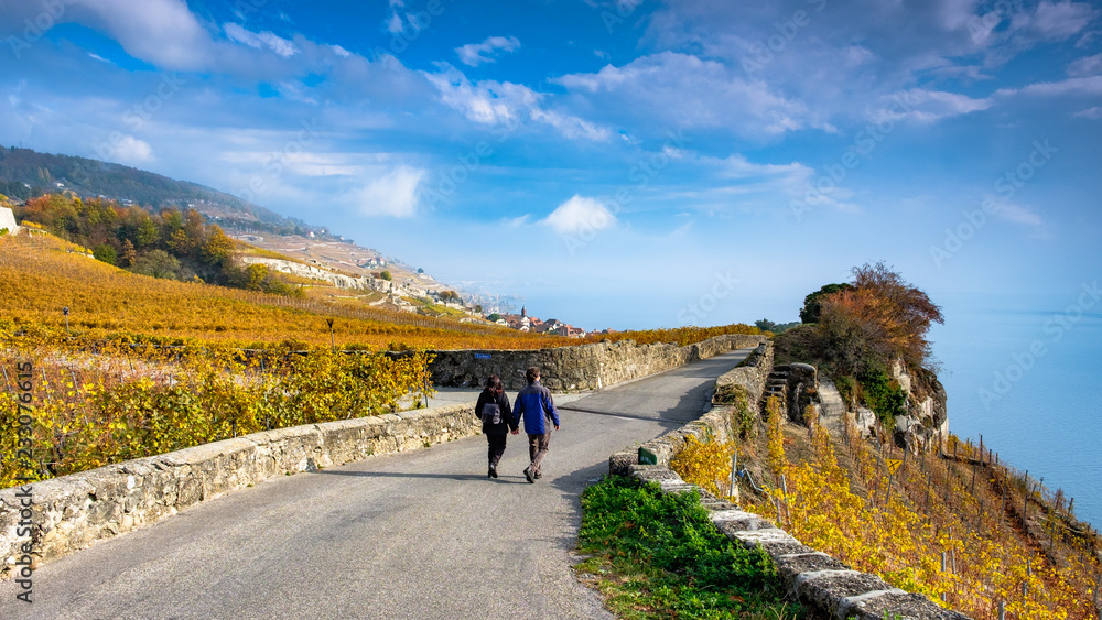 Young couple hiking in the beautiful autumn winery area Lavaux, Switzerland.