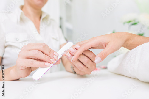 Young woman getting manicure in beauty salon. Close-up