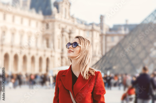 Fotografie Style redhead girl in red coat and bag on parisian street in autumn season time