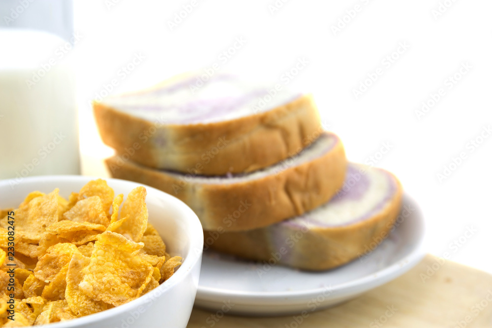 Golden Cornflakes (detailed close-up shot) and milk on an old wooden table Golden Cornflakes (detailed close-up shot) and milk on an old wooden table