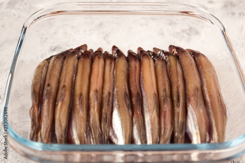 Small sea fish, entirely laid in a dense row on the bottom of glassware. photo