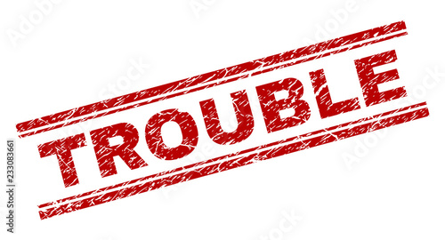 TROUBLE seal print with distress effect. Red vector rubber print of TROUBLE text with unclean texture. Text caption is placed between double parallel lines.