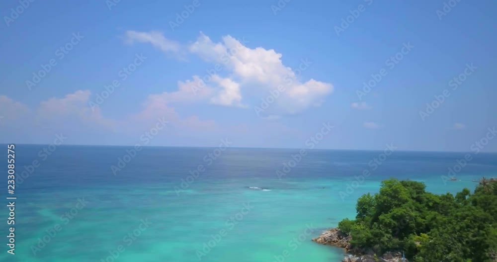 High altitude aerial view colorful Andaman sea pan right showing colorful emerald coastal rocky shore meeting forest on Thai tropical island, Ko Lipe, Thailand. 4k 1.9:1 23.976fps High altitude aerial view colorful Andaman sea pan right showing colorful emerald coastal rocky shore meeting forest on Thai tropical island, Ko Lipe, Thailand. 4k 1.9:1 23.976fps