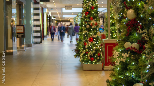 christmas tree in focus right side of frame, people blurred in left side of frame
