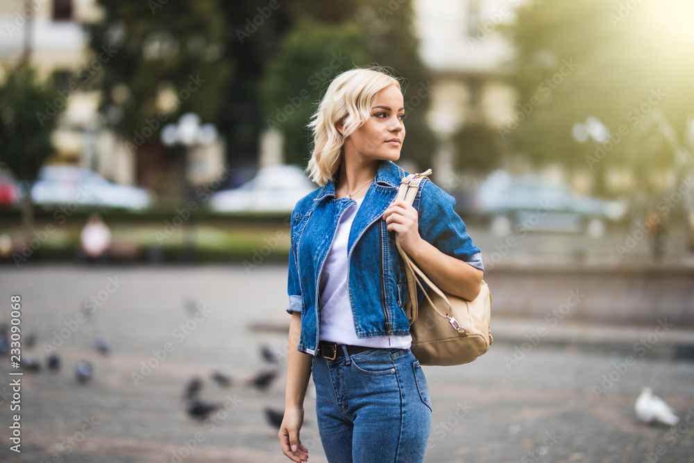Portrait of woman walking in street with backpack summer city street Portrait of woman walking in street with backpack summer city street