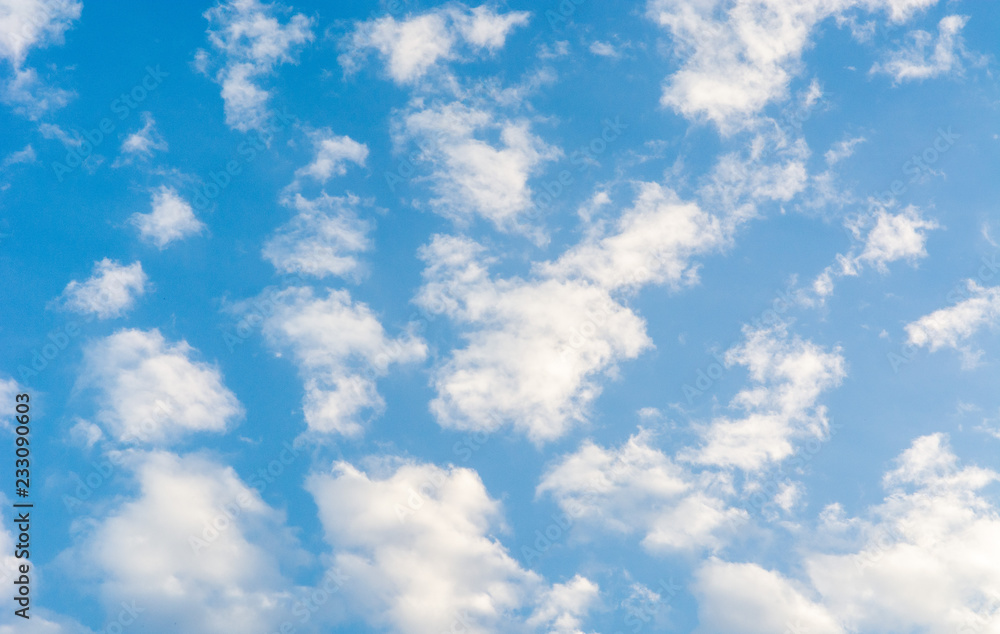 Blue bright summer sky with fluffy clouds on a sunny day Blue bright summer sky with fluffy clouds on a sunny day