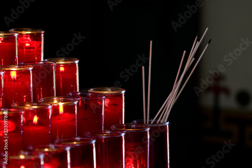 Lit candles against black background at Monastary