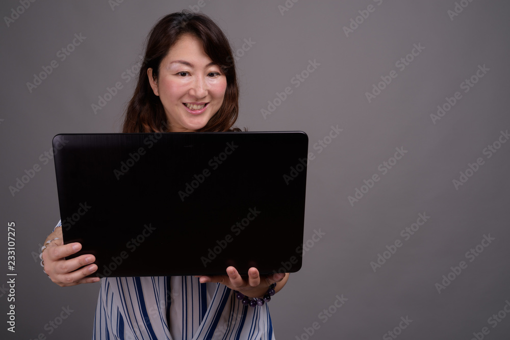 Mature beautiful Asian businesswoman using laptop computer Mature beautiful Asian businesswoman using laptop computer