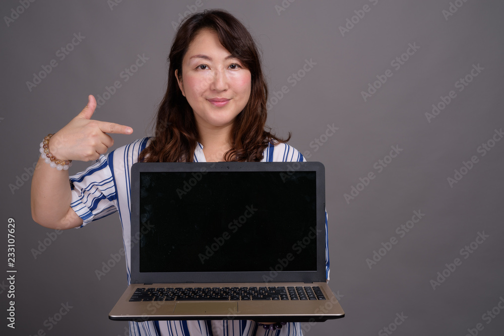 Asian businesswoman showing copy space from laptop computer Asian businesswoman showing copy space from laptop computer