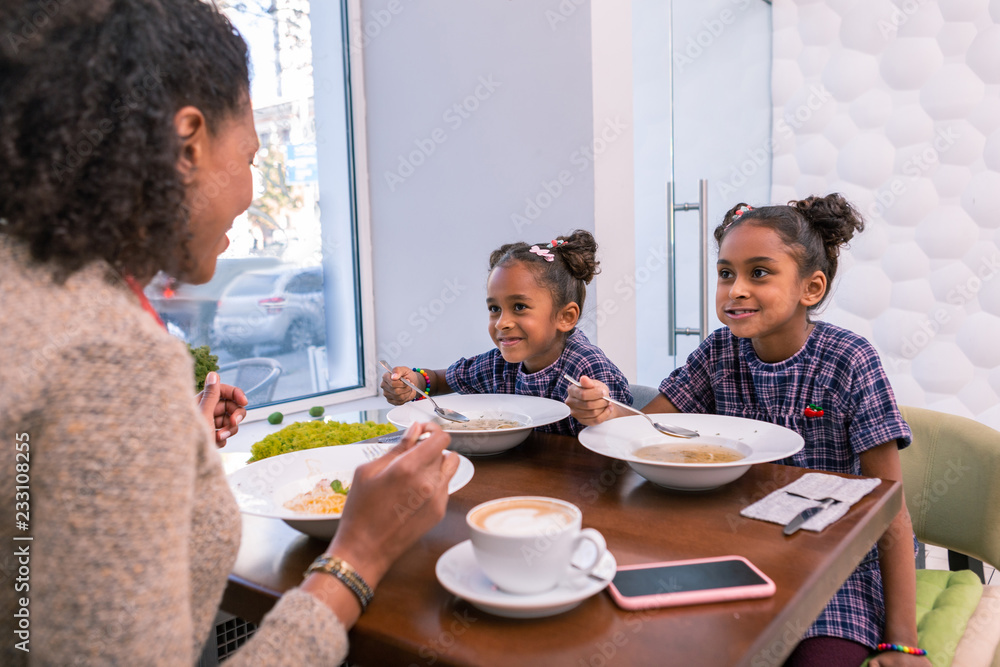 Soup in restaurant. Mother and two daughters feeling relaxed while eating soup in restaurant on weekend Soup in restaurant. Mother and two daughters feeling relaxed while eating soup in restaurant on weekend