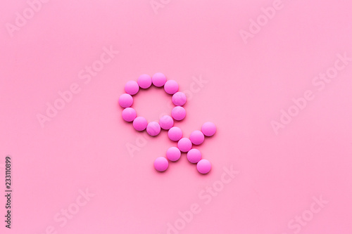 Female diseases. Female gender icon symbol made of pills on pink background top view copy space