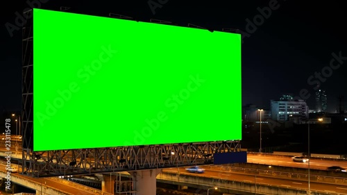 Green screen of advertising billboard on expressway during the twilight with city background in Bangkok, Thailand.