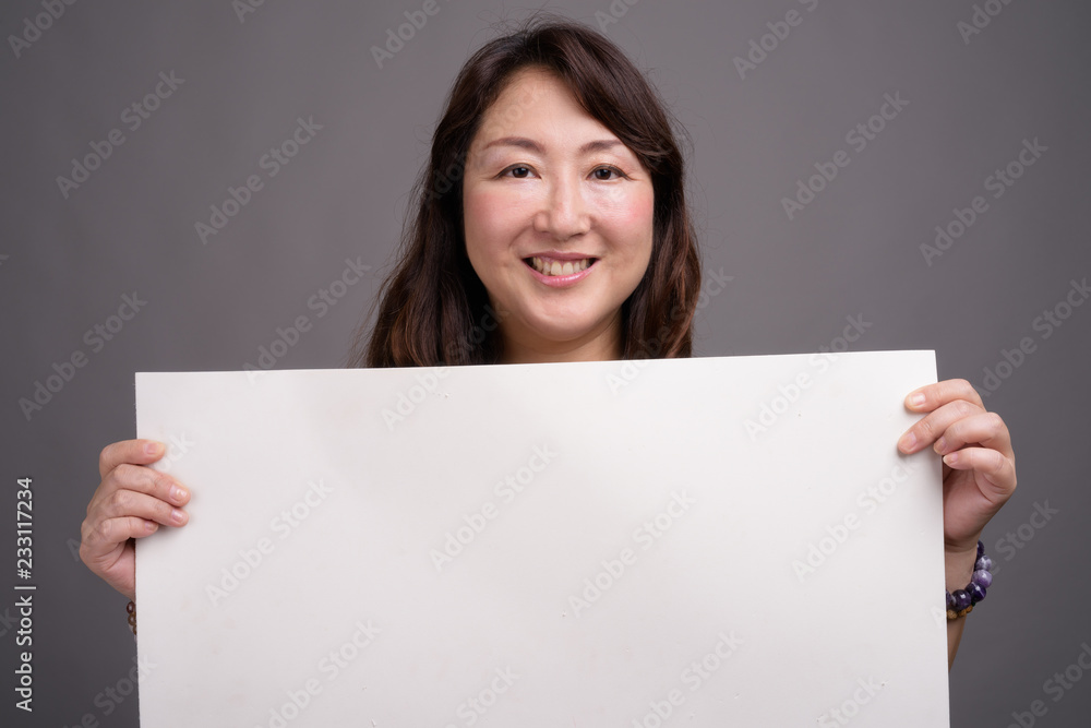 Mature beautiful Asian businesswoman showing copy space Mature beautiful Asian businesswoman showing copy space