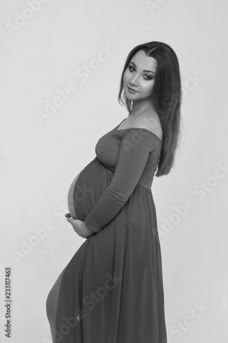 pregnant woman in dress stroking her belly