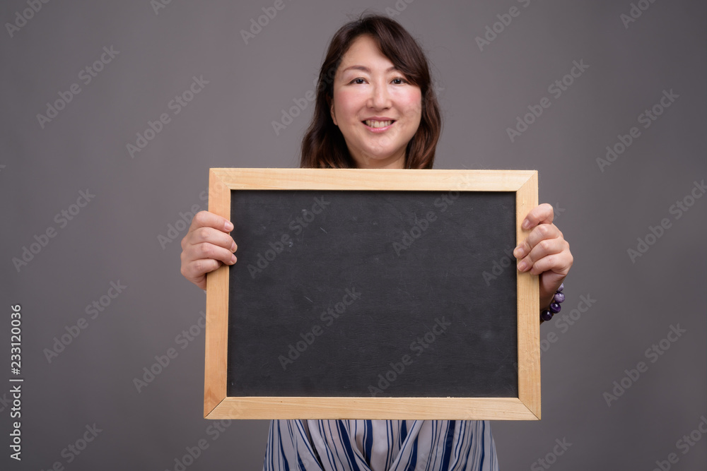 Asian businesswoman holding blackboard with copy space