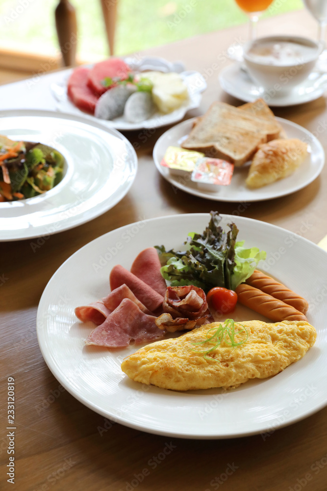 Breakfast set Omelette with sausage bacon and salad on wood background Breakfast set Omelette with sausage bacon and salad on wood background