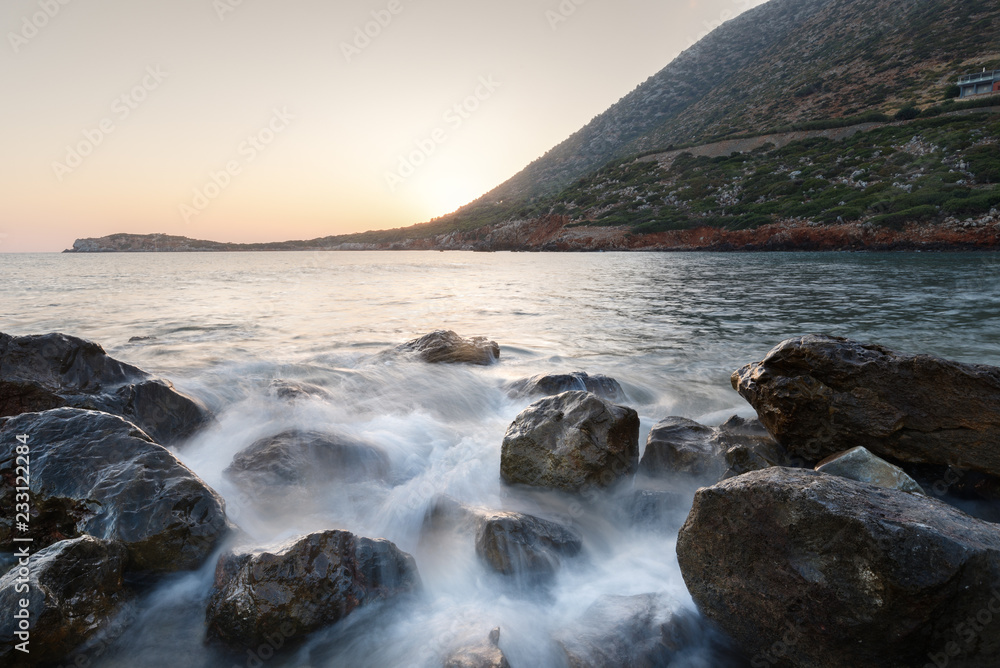 Obraz premium sunsets and sunrises on the rocky coast texture creating amazing patterns and the sea with waves in the background