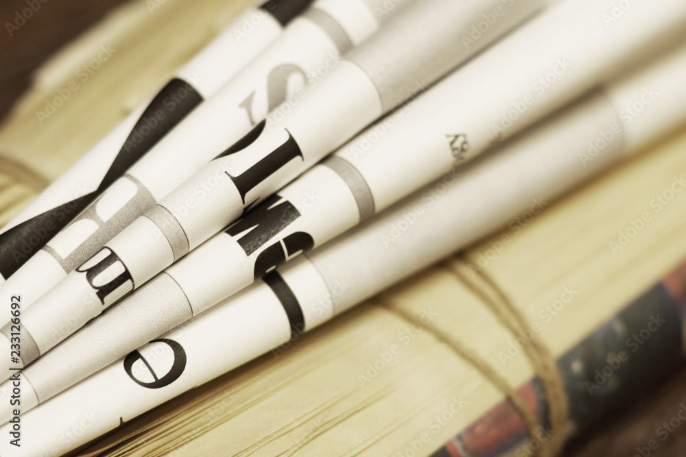 Stack of newspapers and magazines with partially shown headlines and articles as concept for news or media press background Stack of newspapers and magazines with partially shown headlines and articles as concept for news or media press background