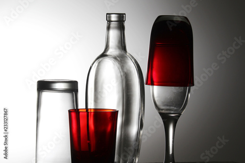 A transparent bottle and red glasses	