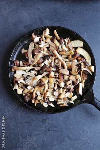 A pan on mixed mushrooms including king trumpet, piopinni, maitake, shiitake, oyster and matsutake mushrooms photo