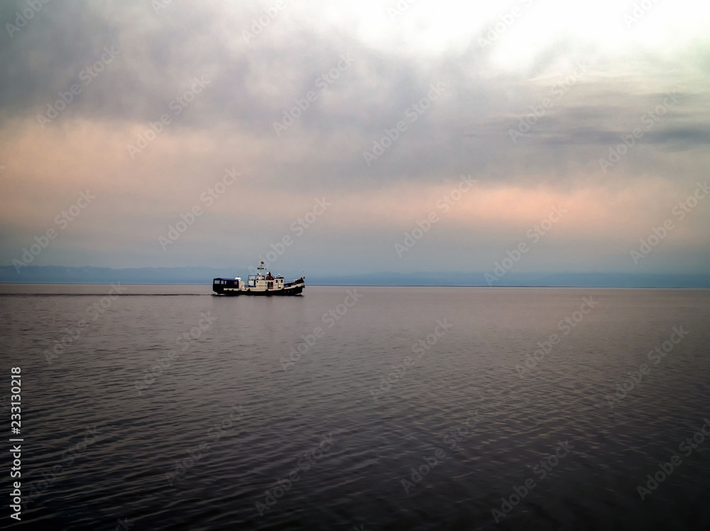 Cargo ship sailing in late afternoon with with storm clouds. Dangerous weather. Cargo ship sailing in late afternoon with with storm clouds. Dangerous weather.
