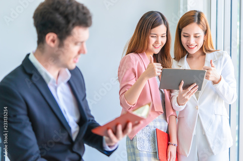 Business man is taking note in front of two female office worker