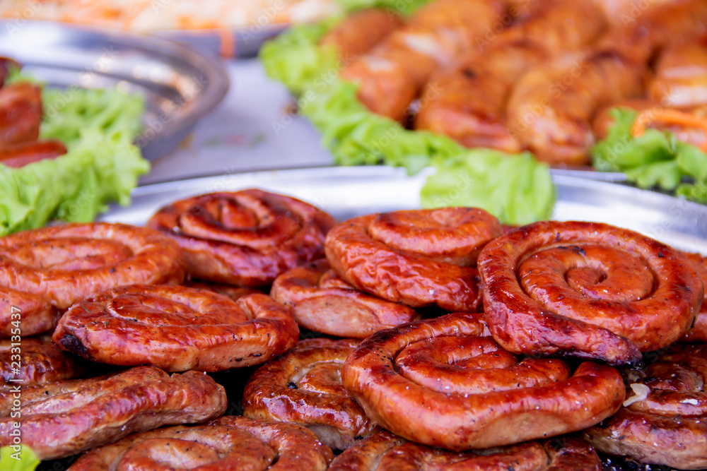Grilled or Roasted spiral pork sausages with rosemary, salt and peper on plate Grilled or Roasted spiral pork sausages with rosemary, salt and peper on plate