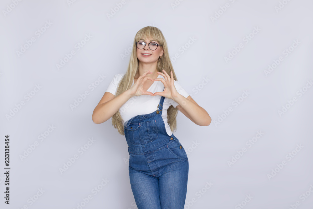 Young blond woman in jeans overalls and glasses Young blond woman in jeans overalls and glasses