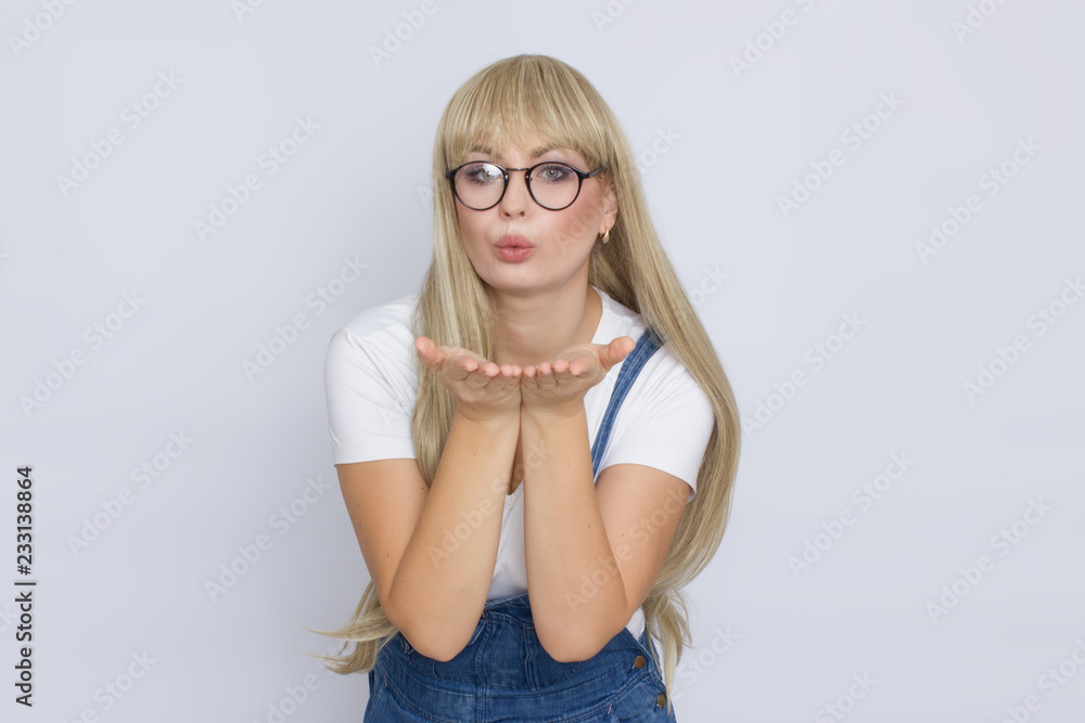 Young blond woman in jeans overalls and glasses Young blond woman in jeans overalls and glasses