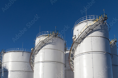 Large white Industrial tanks for petrol and oil.