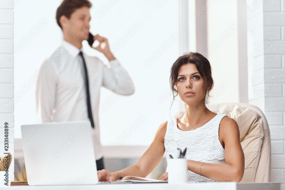 Caucasion man and woman working together in a modern office Caucasion man and woman working together in a modern office