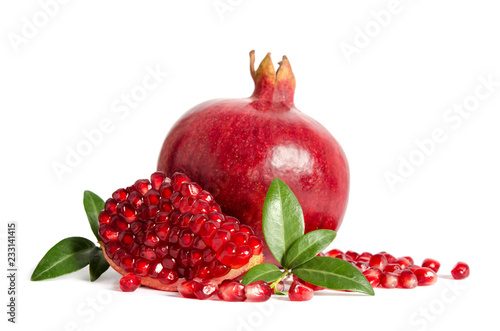 one whole and part of a pomegranate with pomegranate seeds and leaves isolated on white background